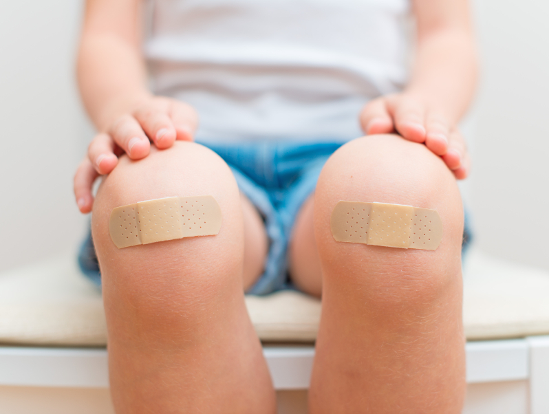 Child knee with an adhesive bandage.